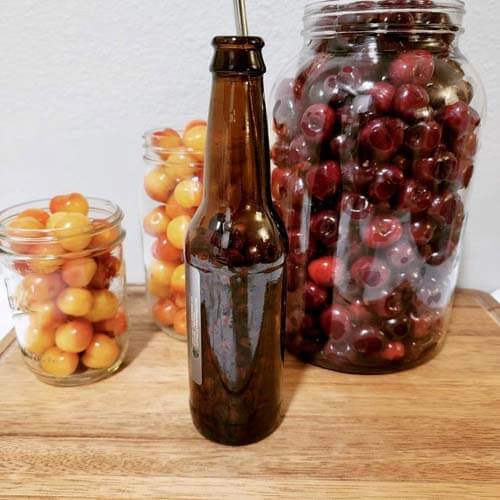 cherries-in-mason-jars-and-an-empty-root-beer-bottle-which-can-be-used-as-a-cherry-pitter