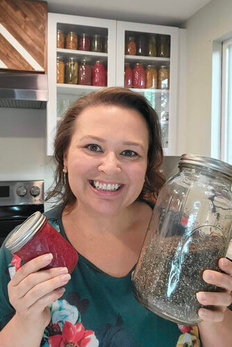 amy-cross-holding-strawberry-jam-and-chia-seeds-in-her-kitchen