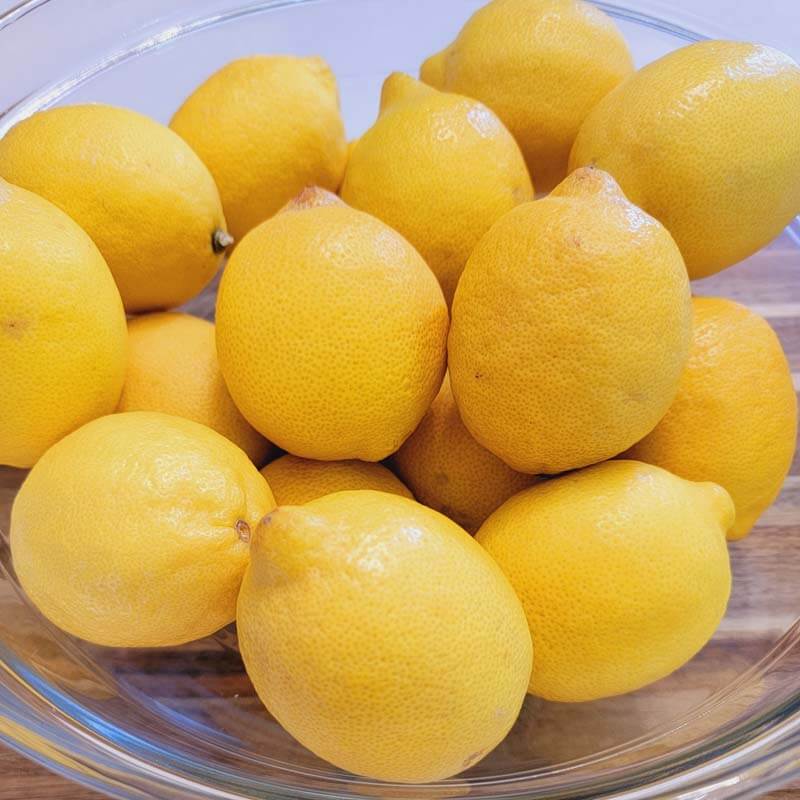 Clear glass bowl of fresh lemons
