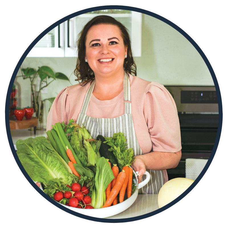 Amy in her kitchen holding a tray of fresh produce