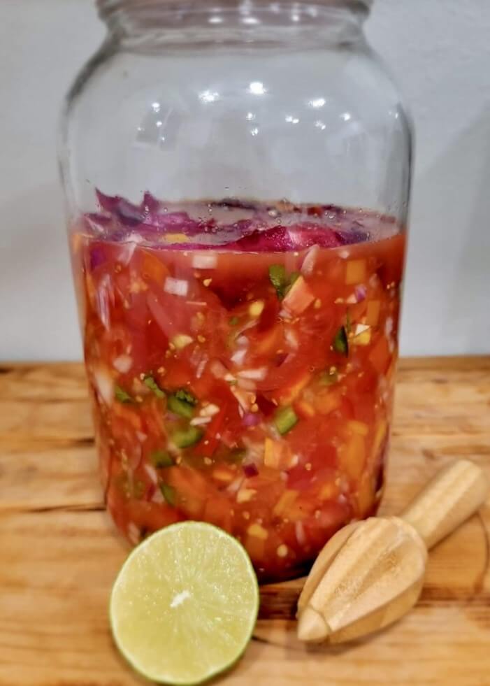 Homemade Salsa in jar with lime and citrus juicer