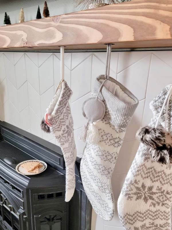 Peanut Butter Brittle for Santa on a plate on top of the fireplace with Christmas stockings hung on the mantel.