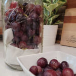 Grapes in a white square dish and store grapes in an airtight glass jar with a lid.