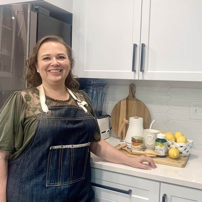 Amy in her kitchen showing off the winter wellness products she uses to stay healthy.