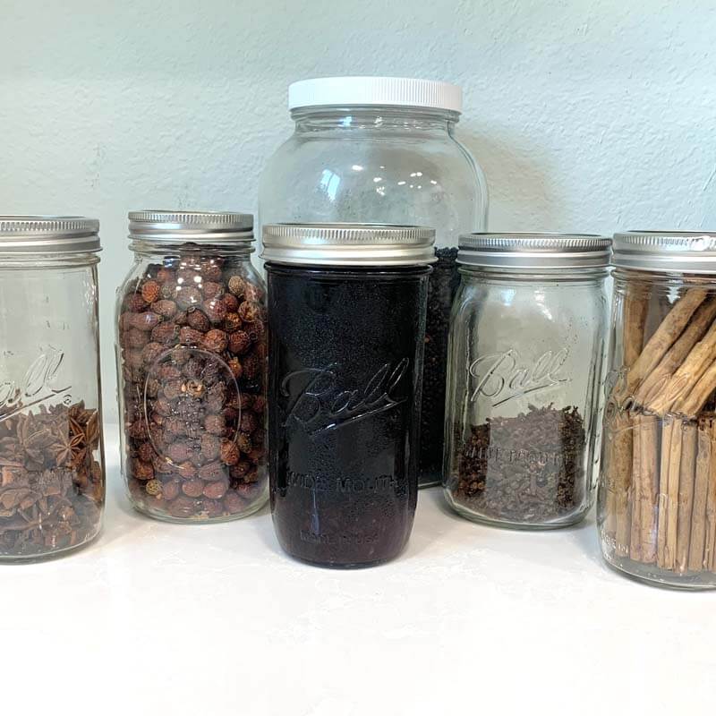 Elderberry Syrup Ingredients in glass jars sitting on the counter.